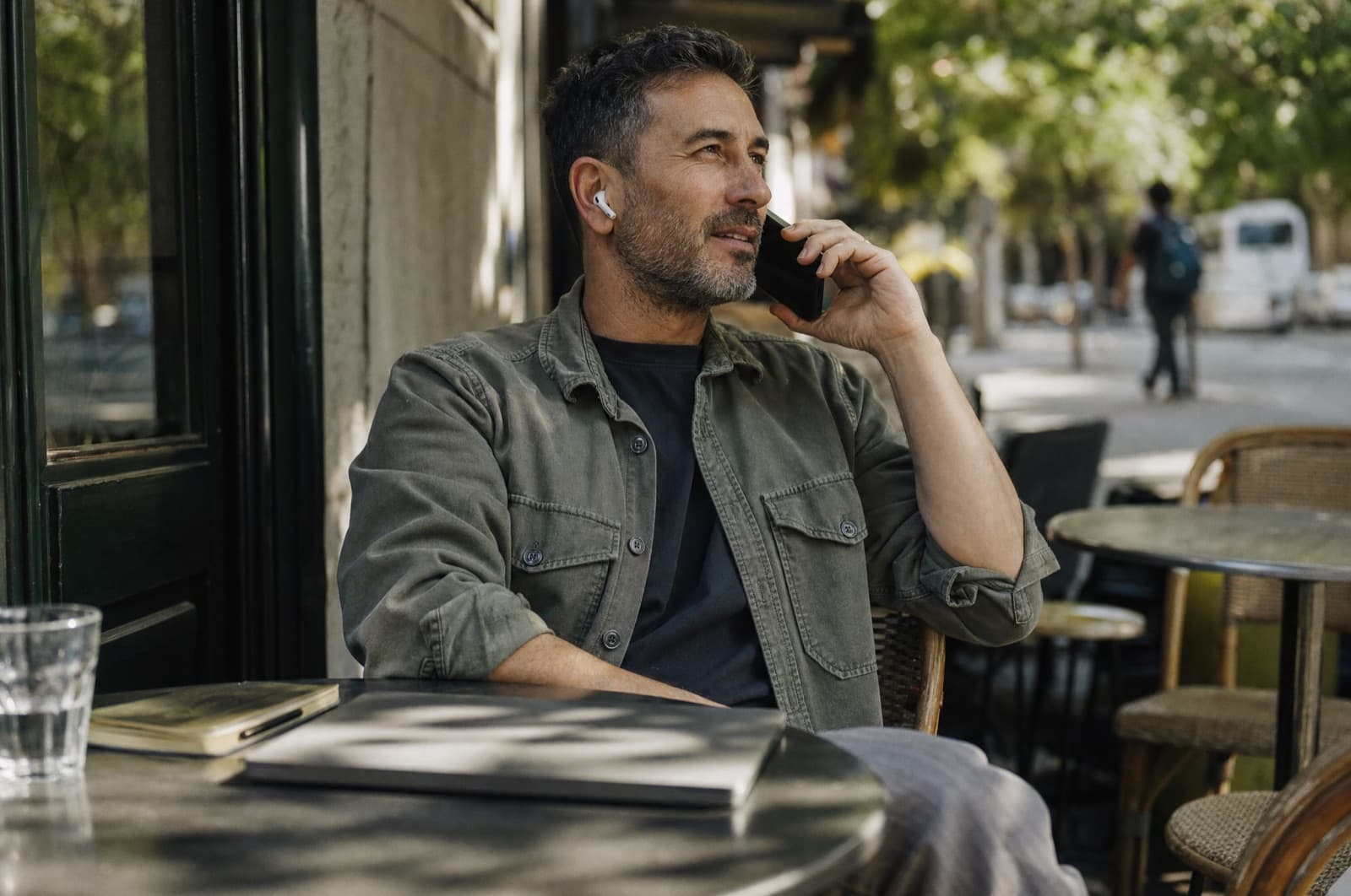 A man on a phone call at a cafe table
